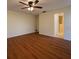 Bedroom with laminate floors, ceiling fan with light, and an en suite bathroom with walk-in shower at 12180 Maple St, Dunnellon, FL 34432