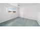 Bright bedroom featuring plush blue carpeting, white walls, a white ceiling fan, and a window with a view of a lake at 12180 Maple St, Dunnellon, FL 34432