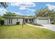 Charming single-story home with a well-manicured lawn, beautiful landscaping, and an attached garage at 12180 Maple St, Dunnellon, FL 34432