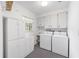 Well-equipped laundry room with ample storage cabinets, a utility sink, and modern washer and dryer units at 12180 Maple St, Dunnellon, FL 34432