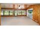 Living area features a unique wood paneled wall design, large windows, and plush carpeting at 12180 Maple St, Dunnellon, FL 34432