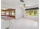 Bright living room featuring tile floors, a ceiling fan, and an adjacent sunroom filled with natural light at 12180 Maple St, Dunnellon, FL 34432