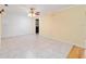 Spacious living area with neutral tile flooring and a vintage ceiling fan with overhead lighting at 12180 Maple St, Dunnellon, FL 34432