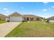 Charming single-story home featuring a well-maintained lawn, attached garage, and red shutters at 15470 Sw 34Th Ave, Ocala, FL 34473