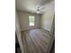 Cozy bedroom with neutral walls, wood-look floors, and a bright window and ceiling fan at 15099 Sw 29Th Terrace Rd, Ocala, FL 34473