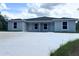 A modern duplex boasts a clean facade and a spacious concrete driveway under a bright sky at 15099 Sw 29Th Terrace Rd, Ocala, FL 34473