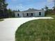 New duplex with a concrete driveway offers a modern feel with a green lawn and surrounding trees at 15099 Sw 29Th Terrace Rd, Ocala, FL 34473