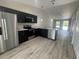 Kitchen with dark cabinetry, stainless appliances, granite counters and wood-look floors at 15099 Sw 29Th Terrace Rd, Ocala, FL 34473