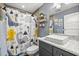 Bright bathroom with a modern sink, dinosaur-themed shower curtain, and gray walls at 5118 Sw 197Th Ter, Dunnellon, FL 34431