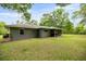 Rear exterior of home with a screened-in porch, neutral paint, and a well-maintained lawn at 5118 Sw 197Th Ter, Dunnellon, FL 34431