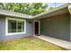 Home entrance with a wood door, siding, and green grass at 5118 Sw 197Th Ter, Dunnellon, FL 34431