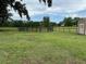 A scenic view of a fenced field with lush grass, framed by mature trees and a clear sky at 6020 Nw 2Nd Ave, Ocala, FL 34475