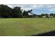A verdant and spacious pasture is enclosed by fencing, set against a backdrop of lush trees and blue sky at 6020 Nw 2Nd Ave, Ocala, FL 34475