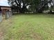 View of a large grassy yard next to an old wooden shed at 6020 Nw 2Nd Ave, Ocala, FL 34475