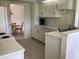 Well-lit kitchen boasting white appliances, cabinetry, and a glimpse of the dining area at 9224 Sw 91St Cir, Ocala, FL 34481