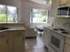 Open kitchen flowing to living area, featuring white cabinets and stainless steel microwave at 9224 Sw 91St Cir, Ocala, FL 34481