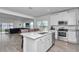 Bright, modern kitchen features a center island, stainless steel appliances, and a seamless open floorplan at 9312 Sw 58Th Cir, Ocala, FL 34476