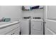Functional laundry room with modern washer, dryer, utility sink, and ample shelving for organized storage at 9312 Sw 58Th Cir, Ocala, FL 34476
