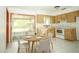 Cozy kitchen with wooden cabinets, white appliances, and a breakfast nook at 11128 Sw 75Th Ave, Ocala, FL 34476