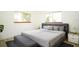 Calm main bedroom with a gray upholstered bed, soft lighting, and a comfortable seating area at 11128 Sw 75Th Ave, Ocala, FL 34476