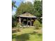 Rustic backyard shed with glass doors, complemented by lush landscaping and hanging plants, creating a serene retreat at 35 Lake Wood Cir, Ocala, FL 34482