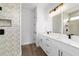 Elegant bathroom featuring a double vanity, stone countertops, modern fixtures, decorative tile and glass shower at 36 Pine Radl, Ocala, FL 34472