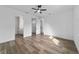 Spacious bedroom with modern wood-look ceramic tile flooring, a ceiling fan, and a view into ensuite bathroom and closet at 36 Pine Radl, Ocala, FL 34472