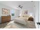 Beautifully staged bedroom featuring wood-look ceramic tile flooring, neutral decor, a plush bed, and a bright window at 36 Pine Radl, Ocala, FL 34472
