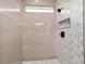 Stylish shower with beige ceramic tile surround, modern fixtures and unique mosaic feature wall and niche at 36 Pine Radl, Ocala, FL 34472