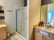 Well-maintained bathroom featuring a glass enclosed shower, neutral tile floors, and storage cabinets at 9053 Sw 103Rd Ave, Ocala, FL 34481