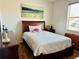 Cozy bedroom with hardwood floors, natural light, and a comfortable bed with tasteful decorations at 9053 Sw 103Rd Ave, Ocala, FL 34481