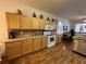 Kitchen featuring light wood cabinets, tile backsplash, and modern appliances with an open floor plan at 9053 Sw 103Rd Ave, Ocala, FL 34481