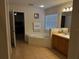 Bright bathroom featuring a soaking tub, vanity sink, and tiled flooring for easy maintenance at 4853 Sw 53Rd Rd, Ocala, FL 34474