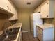 Galley kitchen featuring white cabinets, stainless steel sink, and matching appliances at 5024 Se 109Th St, Belleview, FL 34420