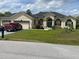 The home's front elevation shows the well-manicured lawn, circular driveway, and black roof at 5323 Sw 111Th Lane Rd, Ocala, FL 34476