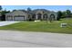 Charming single-story home with a well-manicured lawn and a three-car garage, set against a blue sky at 5323 Sw 111Th Lane Rd, Ocala, FL 34476