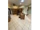 Open kitchen with wood cabinets, tile floors, stainless appliances, and a breakfast bar overlooking the living space at 5323 Sw 111Th Lane Rd, Ocala, FL 34476