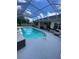 A screened pool with clear water and a hot tub, surrounded by a spacious deck at 5323 Sw 111Th Lane Rd, Ocala, FL 34476
