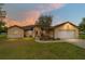 Charming single-story home with a well-manicured lawn and attached two-car garage at sunset at 6701 Nw 6Th Ave, Ocala, FL 34475