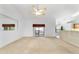 Bright living room with a ceiling fan, carpet flooring, and a view of the screened-in porch at 6701 Nw 6Th Ave, Ocala, FL 34475