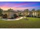 Stunning home exterior at twilight featuring lush landscaping and a manicured lawn at 18498 Sw 69Th Loop, Dunnellon, FL 34432