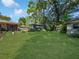 Lush backyard featuring a green lawn and mature trees, perfect for outdoor activities and relaxation at 4085 Se 23Rd Ter, Ocala, FL 34480