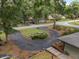Circular driveway leading to a charming home, surrounded by lush greenery and mature trees in a peaceful setting at 4085 Se 23Rd Ter, Ocala, FL 34480