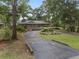 Charming single-story home with a landscaped front yard and a circular driveway, surrounded by mature trees at 4085 Se 23Rd Ter, Ocala, FL 34480