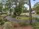 Lush front yard featuring mature trees, landscaping, and a circular driveway at 4085 Se 23Rd Ter, Ocala, FL 34480