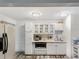 Bright kitchen features white cabinets, stainless steel appliances, and wood-look flooring at 4085 Se 23Rd Ter, Ocala, FL 34480