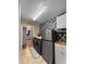 Well-lit laundry room features a gray washer and dryer, stainless fridge, and floral wallpaper at 4085 Se 23Rd Ter, Ocala, FL 34480