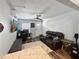 Cozy living room featuring a comfortable leather couch, TV, and wood-look flooring at 4085 Se 23Rd Ter, Ocala, FL 34480