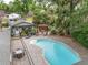 Beautiful pool area with an outdoor kitchen and plenty of seating under mature trees at 4085 Se 23Rd Ter, Ocala, FL 34480