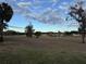 Scenic view of a large, grassy open space with mature trees and community buildings, perfect for recreation at 8142 Fairways Cir # S204, Ocala, FL 34472